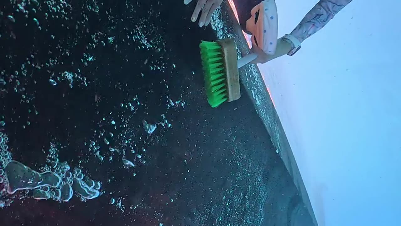Diver Cleans the Underside of a Boat