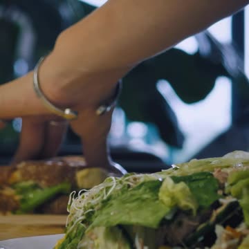 Hands of a woman breaking a sandwich.