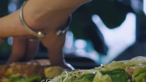 Hands of a woman breaking a sandwich.