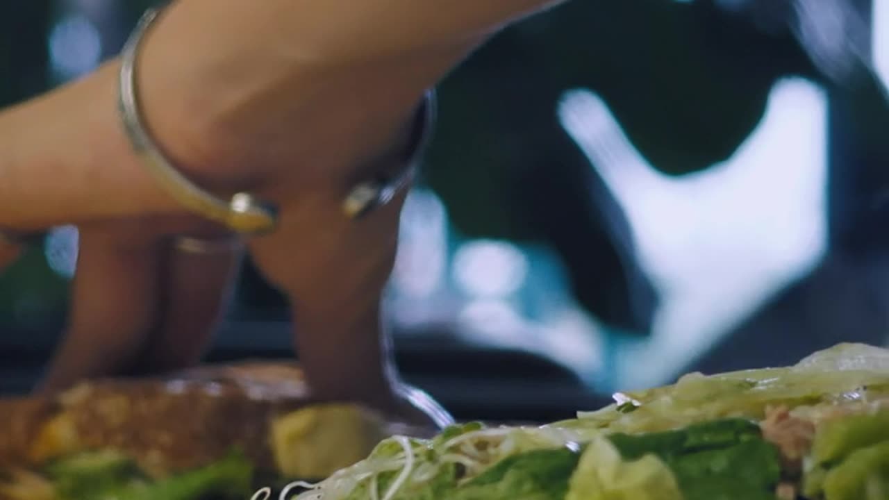 Hands of a woman breaking a sandwich.