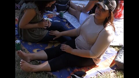 Luodong Massages Woman's Feet On The Blanket At The Park