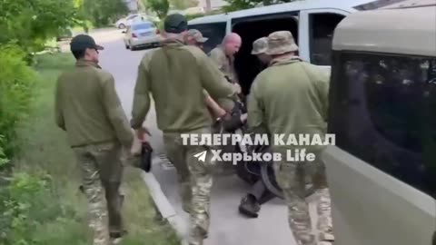 solemn delivery of a volunteer's body to the bus with a bicycle in Kharkiv.