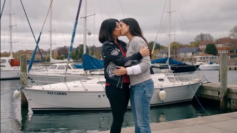 Seaport Serenade – A Passionate Kiss Between Two Stylish Models