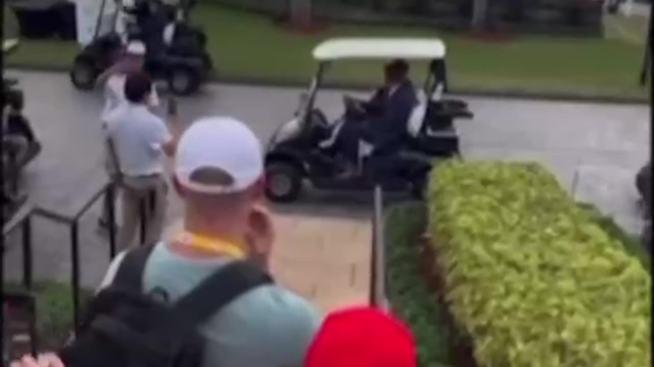 Eric Trump drives his dad, President Donald Trump, on a golf cart in his Doral,