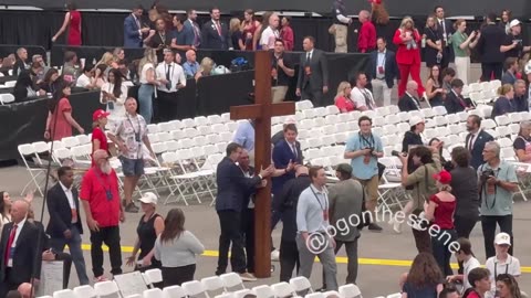 Man carries a large wooden cross at Kirk’s memorial service 🙏