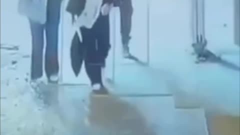A man knocks down a young woman because her hijab