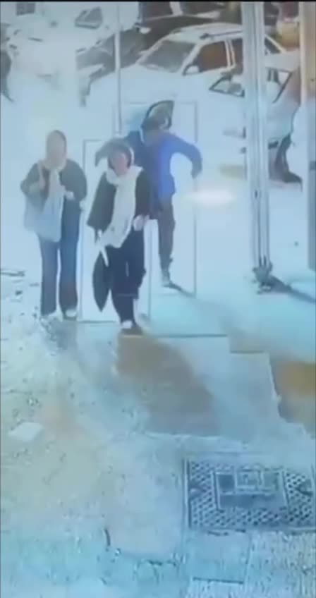 A man knocks down a young woman because her hijab
