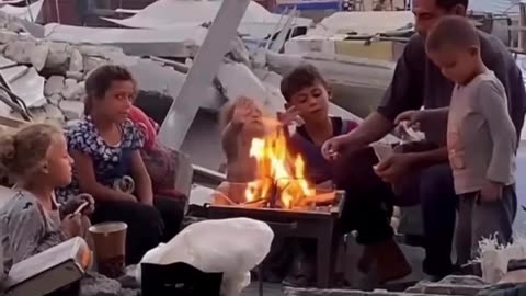 🇵🇸 In northern Gaza, a father sits with his children beside a small fire