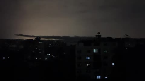 Gaza City skyline is filled with smoke, flashes from strikes light up the sky