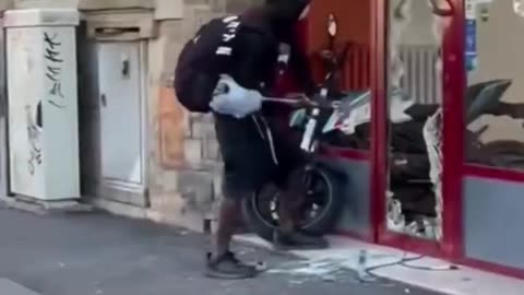 Usual African suspect in Florence wants a motorbike so he smashes window to steal it.