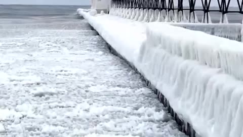 Lake Michigan lighthouse turns into ICE SCULPTURE Winter storms coat the towers in frozen waves
