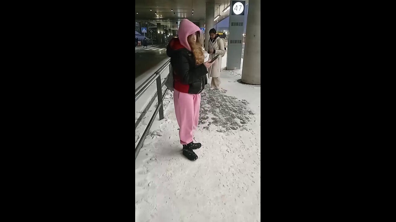 Girl freezes while waiting for the bus.