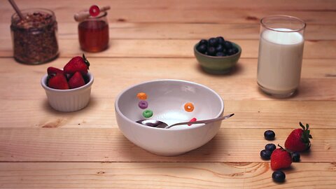 Colorful circles of cereal tumble down into a white bowl on the
