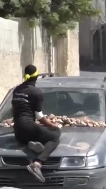a person attacking the Israeli army with a stone