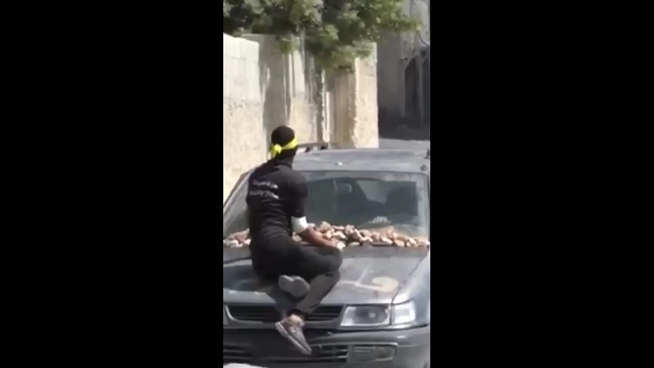 a person attacking the Israeli army with a stone