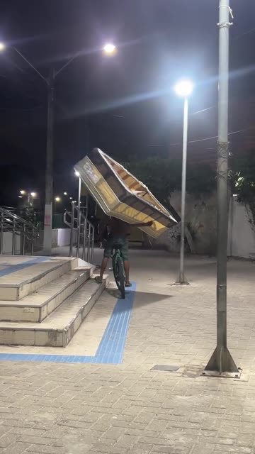 Man Carries a Bed While Riding a Bicycle