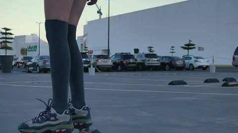 Girl skating slowly in a parking lot