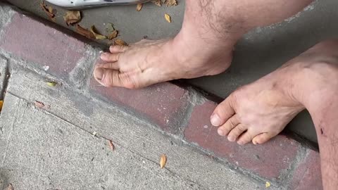 Luodong Massages His Feet On The Front Steps