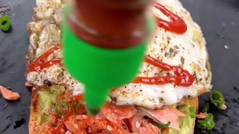 Making Avocado toast, with salmon and egg on top of it