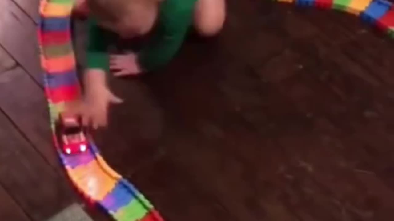 A baby tries to catch his toy