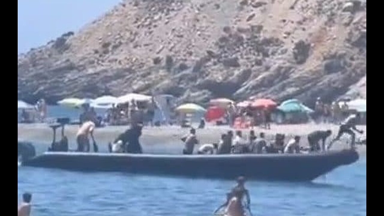 Chaotic Moment Tourists Tackle Migrant Boat Landing on Spanish Beach as Border Crisis Escalates
