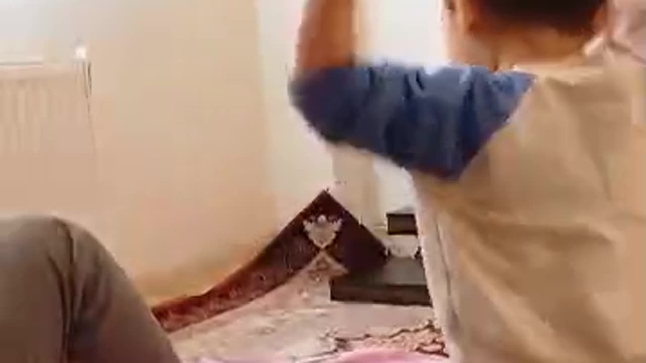 Cute Radmehr's son plays with a piece of tissue paper and laughs