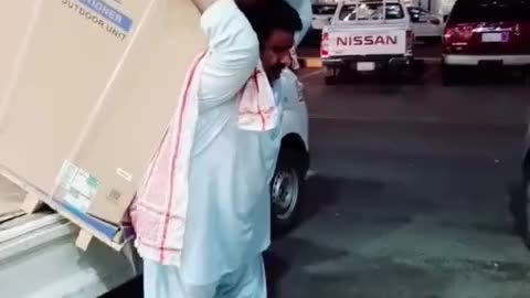 This Pakistani carries an air conditioner on his back