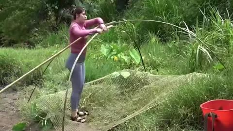 Village girl catching fish from river