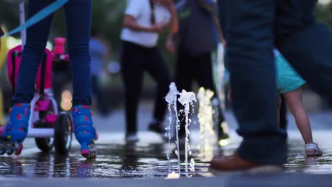 Children playing on water fountain