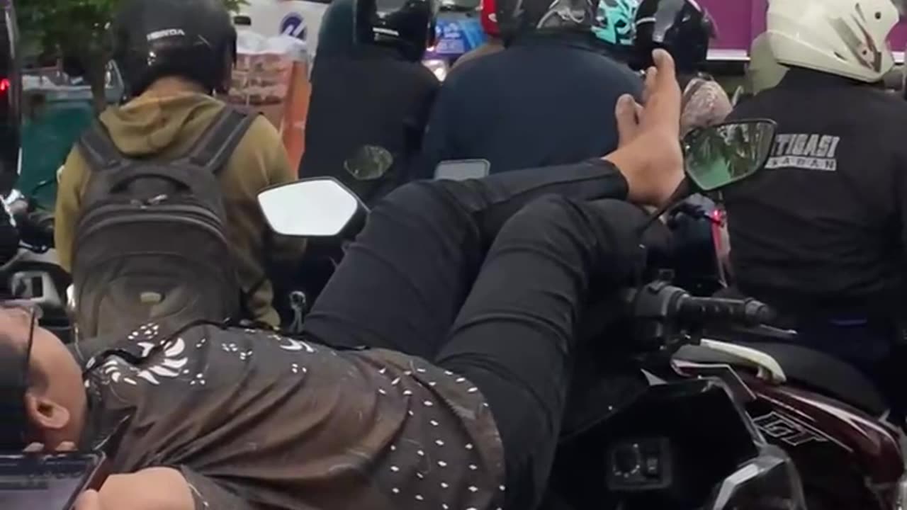 Biker Takes a Nap While Stuck in Gridlock Traffic