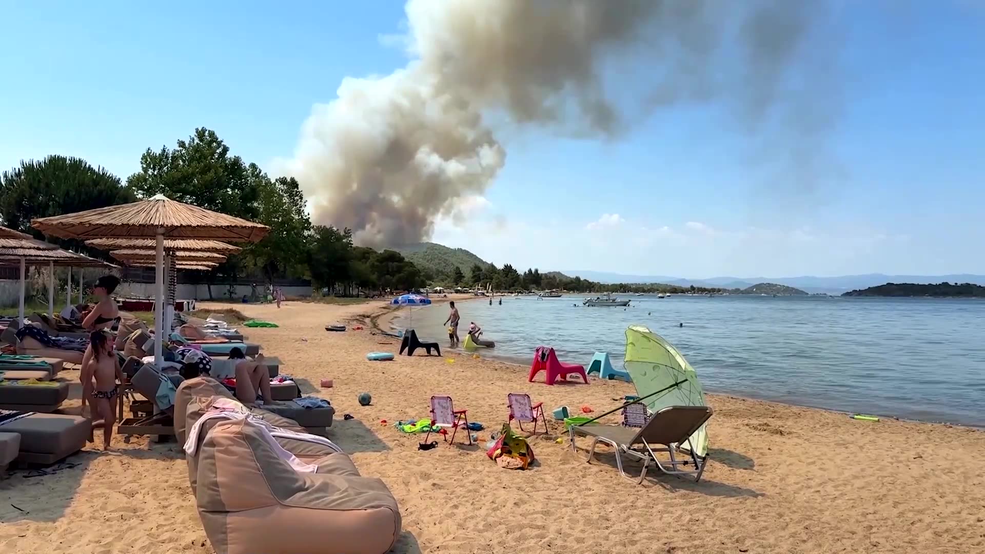 Beach-goers watch as wildfire burns in Greeces Halkidiki