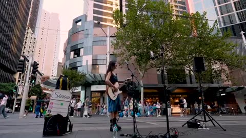 a woman shows her ability on the street by singing so beautifully