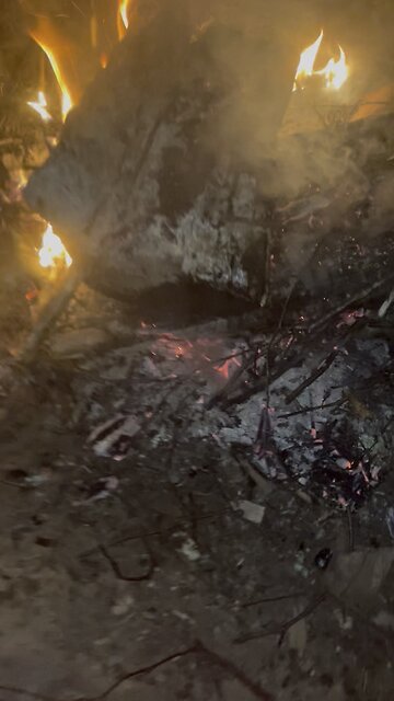 Sitting at a campfire with firework noises in background