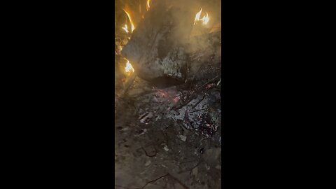 Sitting at a campfire with firework noises in background
