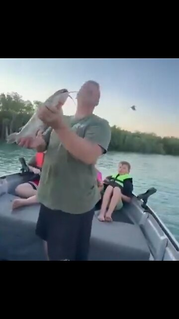 Fisherman feeds an Eagle staring at his catch