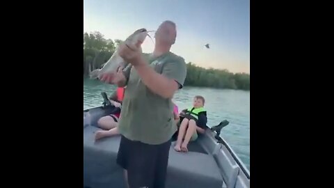 Fisherman feeds an Eagle staring at his catch