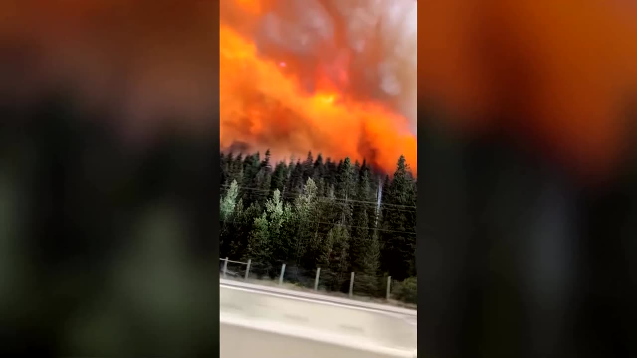Driver films journey through flames as Canada wildfire closes highway