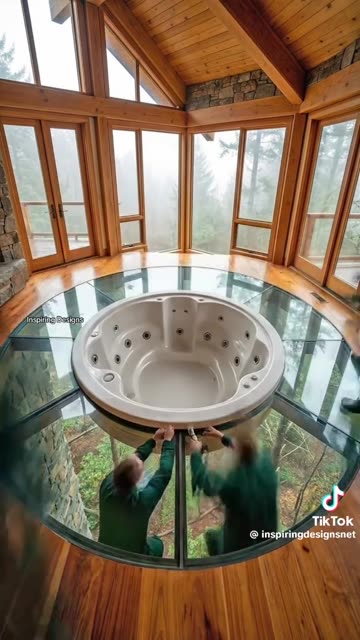 This treetop cabin has a hot tub surrounded by glass that looks down on the forest