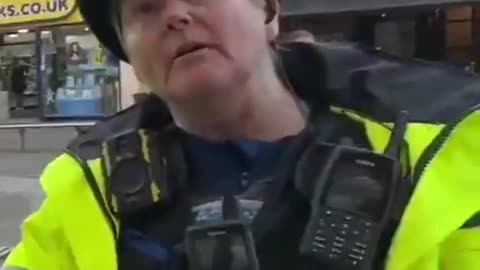 A man takes some photos and is stopped and questioned by British police who