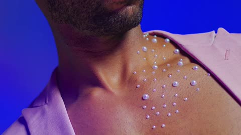 Man in stylish lighting with decorative gems on chest