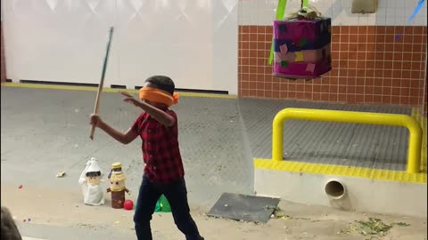 Blindfolded Son Struggles To Strike Pinata