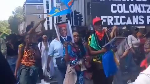 AFRICANS marching through LONDON chanting 'COLONISERS OUT'