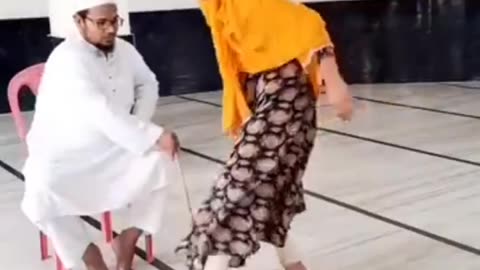 Islamic preacher educates women and little girls with a stick like a farmer usually