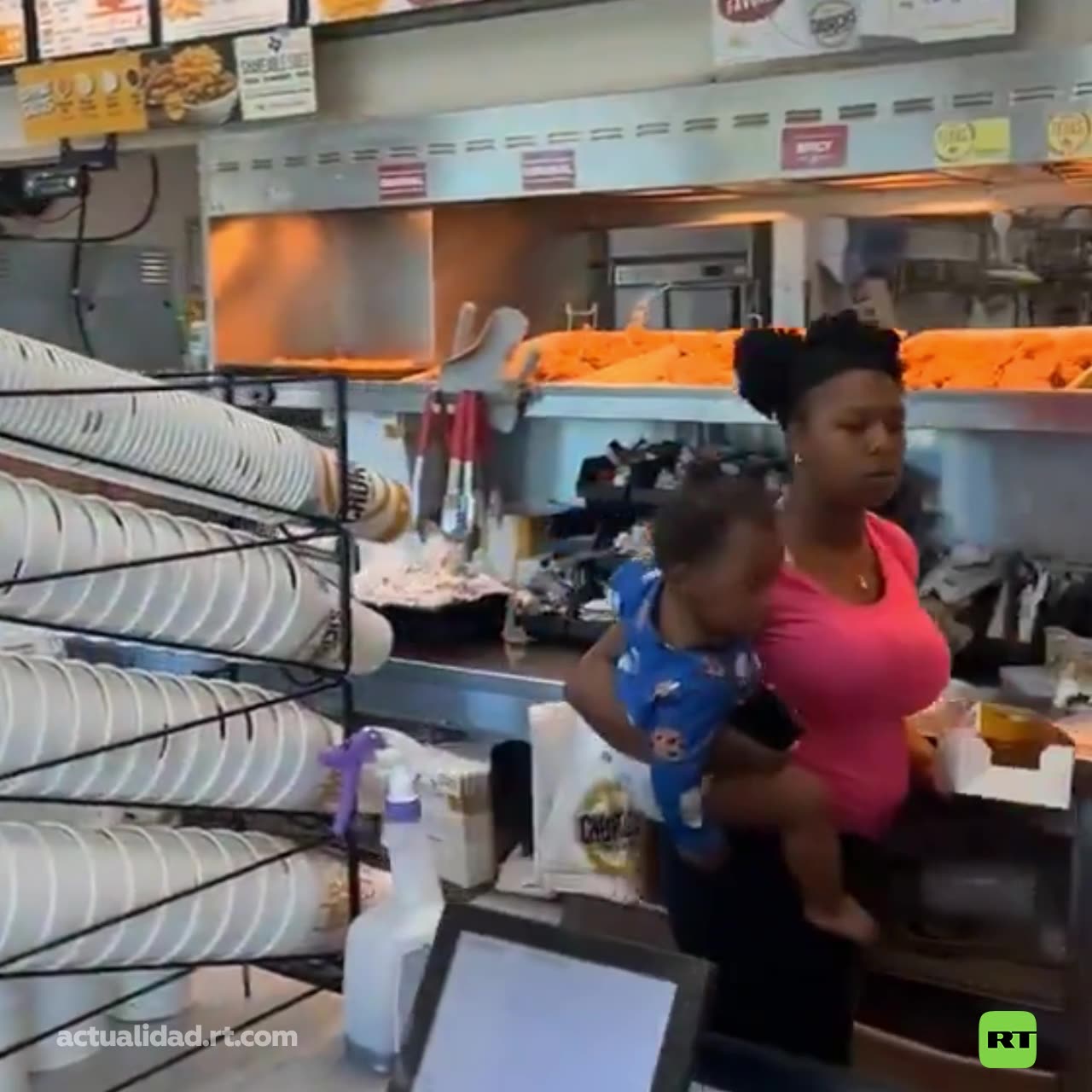 Mujer salta mostrador en restaurante y se sirve su propia comida