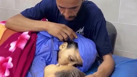Grieving Palestinian father bids final farewell to kids killed in Israeli strike on Nuseirat, Gaza.