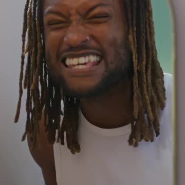 A joyful man belts it out in front of the mirror, using a toothbrush as a mic.