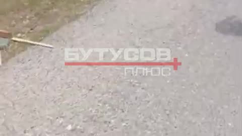 Russian Soldiers Stop to Examine Comrades On Side of Roadway