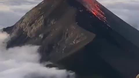 An erupting Volcán de Fuego surrounded by a sea of clouds in Guatemala.