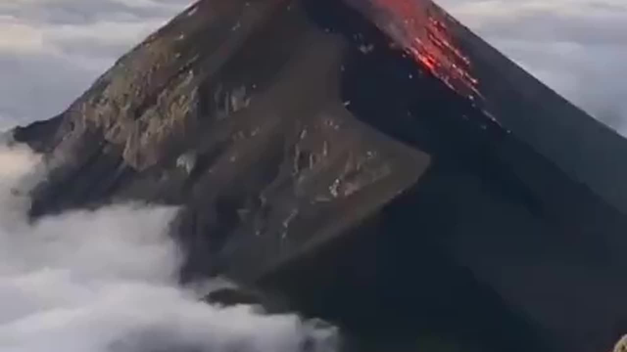 An erupting Volcán de Fuego surrounded by a sea of clouds in Guatemala.