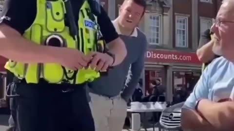 A British officer warns an elderly man that saying “Speak English” could be a hate crime.
